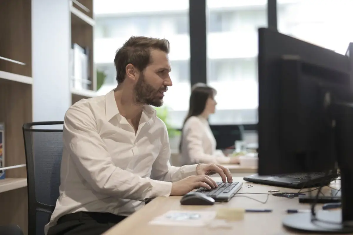 A man works in an office. Looking at a computer.